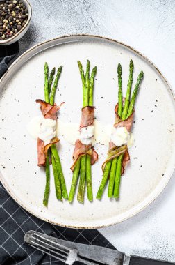 Domuz pastırmasına sarılmış ızgara organik kuşkonmaz. Gri arka plan. Üst görünüm.