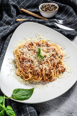 İtalyan makarnası bolonez. Tabakta et ve domates soslu spagetti. Gri arka plan. Üst görünüm.