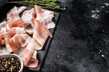 Biber ve kekikli domuz pastırması. Organik çiğ et. Siyah arka plan. Üst Manzara. Boşluğu kopyala.