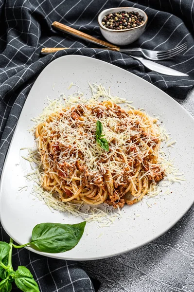 İtalyan makarnası bolonez. Tabakta et ve domates soslu spagetti. Gri arka plan. Üst görünüm.