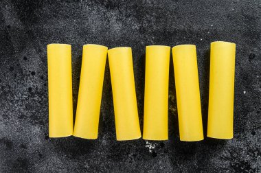 Çiğ cannelloni makarnası. İtalyan mutfağı. Siyah arka plan. en üstteki görünüm.