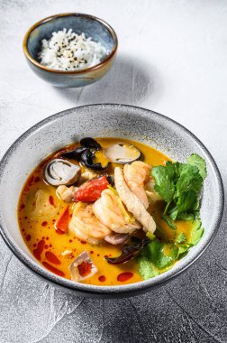 Tom yam kong ya da Tom yum, baharatlı berrak çorba. Tom Yam. Gri arka plan. Üst görünüm.