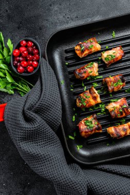 Tavaya sarılmış pastırmalı tavuk göğsü. Siyah arka plan. Üst görünüm.