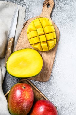 Kesme tahtasında kesilmiş mango meyveleri. Gri arka plan. Üst görünüm.
