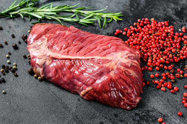 Flat iron steak, raw meat, marbled beef . Black background. Top view.