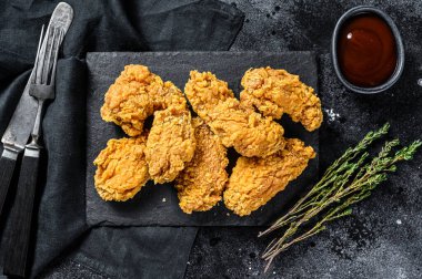 Kızarmış tavuk, patates kızartması ve domates. Siyah arka plan. Üst görünüm.