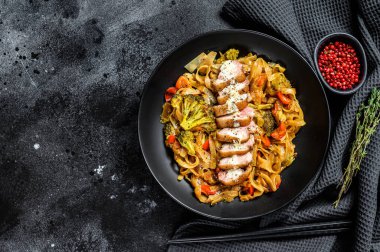 Ördek eti ve sebzeli Wok noodle. Siyah arka plan. Üst Manzara. Boşluğu kopyala.