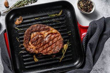 Biberiyeli ve sarımsaklı ızgara biftek. mermer ibeye eti. gri arka plan. en üstteki görünüm.