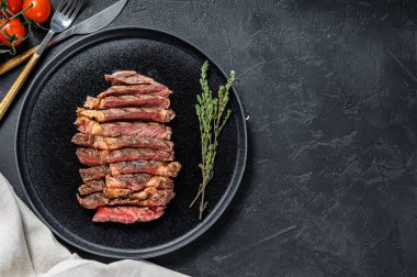 Biberli ızgara biftekli biftek. Siyah arka plan. Üst Manzara. Boşluğu kopyala.
