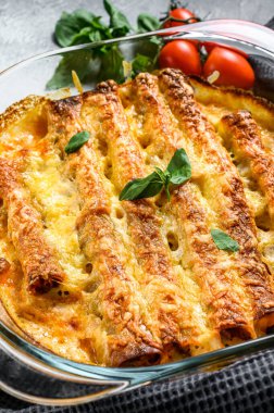Beşamel soslu doldurulmuş cannelloni. Etli makarna, krem soslu, peynirli. Gri arka plan. en üstteki görünüm.