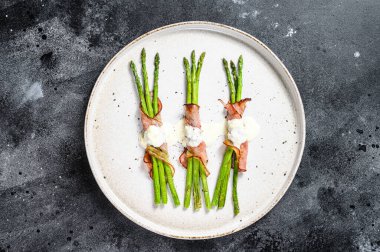 Domuz pastırmasına sarılmış ızgara organik kuşkonmaz. Siyah arka plan. Üst görünüm