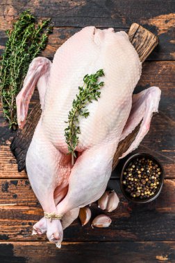 Çiğ yaban ördeği, otlu kümes hayvanı eti. Koyu ahşap arka plan. Üst görünüm.