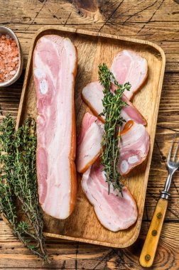 Deri kaplı domuz göbeği, dilimler. Ahşap arka plan. Üst görünüm.