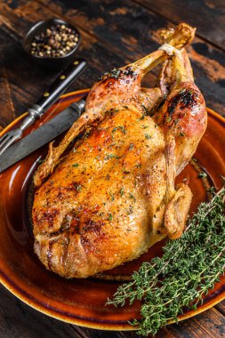 Noel 'de bütün çiftlik ördeğini otlarla pişirdim. Koyu ahşap arka plan. Üst görünüm.