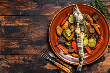 Izgara sebzeli buzlu balık. Karanlık ahşap arka plan. Üst Manzara. Boşluğu kopyala.