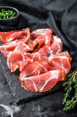 İtalyan usulü pastırmalı Pancetta Piacentina. Domuz eti. Siyah arka plan. Üst görünüm.