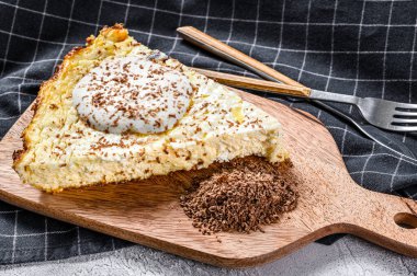 Ahşap kesme tahtasındaki organik süzme peynirden yapılmış Curd güveci. Gri arka plan. Üst görünüm.