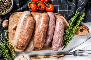 Baharatlı taze domuz eti, sığır eti ve tavuk sosisi. Gri arka plan. Üst görünüm.