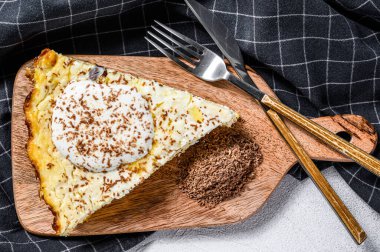 Ahşap kesme tahtasındaki organik süzme peynirden yapılmış Curd güveci. Gri arka plan. Üst görünüm.