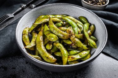 Kızarmış yeşil edamame soya fasulyesi, Japon yemeği. Siyah arka plan. Üst görünüm.