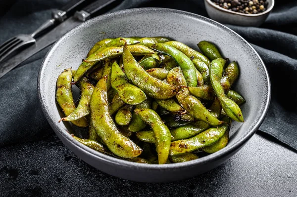 Kızarmış yeşil edamame soya fasulyesi, Japon yemeği. Siyah arka plan. Üst görünüm.