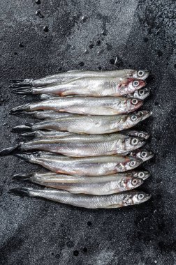 Çiğ taze capelin balığı. Siyah arka plan. Üst görünüm