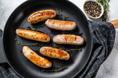 Izgara domuz eti, sığır eti ve tavada baharatlı tavuk sosisi. Gri arka plan. Üst görünüm.