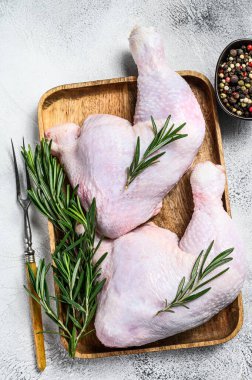 Kesme tahtasında çiğ tavuk bacağı. Beyaz arka plan. Üst görünüm.