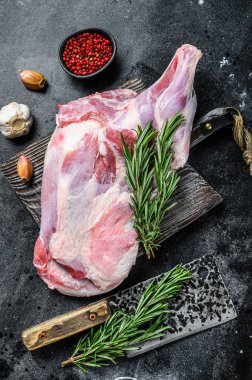 Çiğ kuzu eti sarımsak ve biberiyeyle pişirilmeye hazır. Siyah arka plan. Üst görünüm.