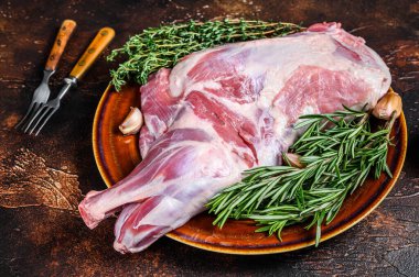 Tabakta taze çiğ keçi eti. Koyu ahşap arka plan. Üst görünüm.