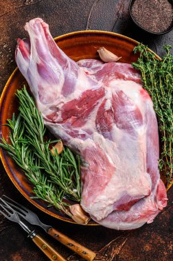 Tabakta taze çiğ keçi eti. Koyu ahşap arka plan. Üst görünüm.