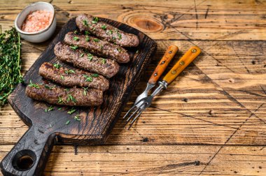 Ev yapımı ızgara Lula kebap sosisleri kesme tahtasında. Ahşap arka plan. Üst Manzara. Boşluğu kopyala.