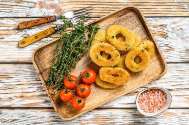 Kızarmış kızarmış soğan halkaları. Beyaz ahşap arka plan. Üst görünüm.