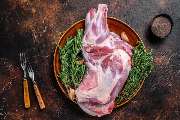 Tabakta taze çiğ kuzu eti. Koyu ahşap arka plan. Üst görünüm.