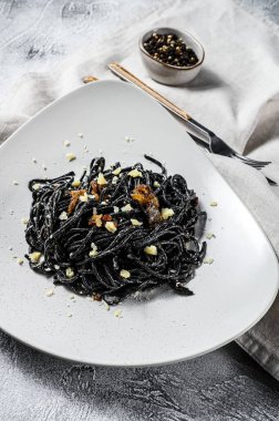 Krema soslu ton balıklı siyah spagetti makarna. Gri arka plan. Üst görünüm.