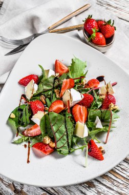 Brie peynirli diyet salatası, çilek, fındık, pazı ve roka. Beyaz arka plan. Üst görünüm.