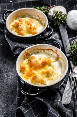 Julienne, tavuk ve mantarlı ve porsiyon şeklinde. Siyah arka plan. Üst görünüm.