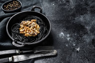 Krema soslu somonlu siyah spagetti makarna. Siyah arka plan. Üst Manzara. Boşluğu kopyala