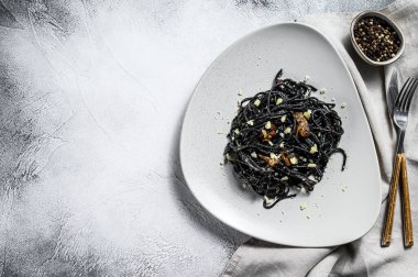 Krema soslu ton balıklı siyah spagetti makarna. Gri arka plan. Üst Manzara. Boşluğu kopyala.