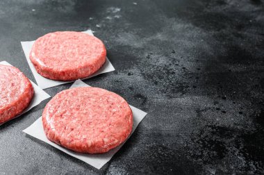 Çiğ et pirzolası, kıyma. Hamburger köftesi. Siyah arka plan. Üst Manzara. Boşluğu kopyala.