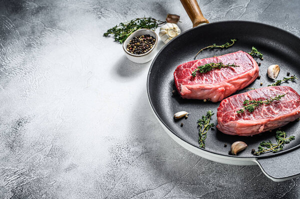 Raw marbled beef steak, top blade meat steak. Gray background. Top view. Copy space.