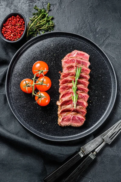 Sliced beef steak Top Blade, black Angus. Black background. Top view.