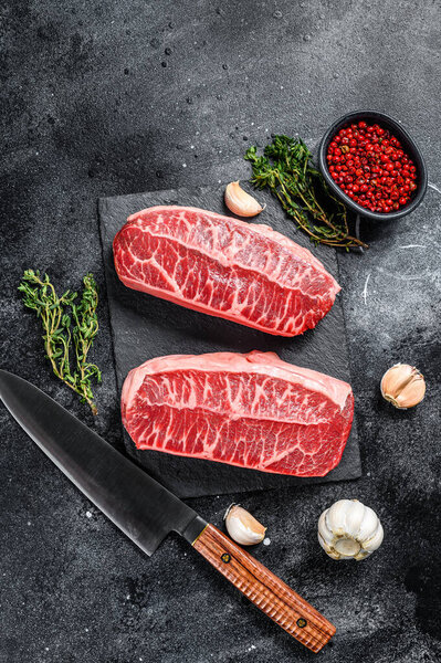 Raw organic meat Twagyu oyster top blade steak. Black background. Top view.
