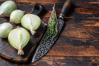 Tahta kesme tahtasındaki çiğ beyaz soğan. Karanlık ahşap arka plan. Üst Manzara. Boşluğu kopyala.