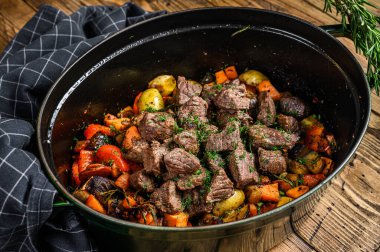 Patates, havuç ve otlu sığır eti güveci. Ahşap arka plan. Üst görünüm.