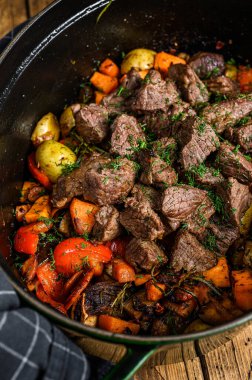 Patates, havuç ve otlu sığır eti güveci. Ahşap arka plan. Üst görünüm.