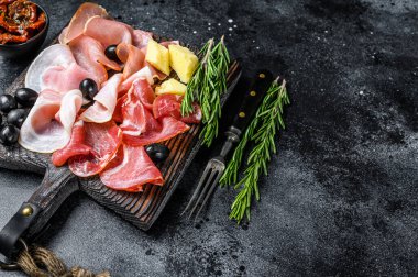 Tütsülenmiş et, kurutulmuş jambon, tuzlanmış et, reçel ve bitkiler. Siyah arka plan. Üst Manzara. Boşluğu kopyala.