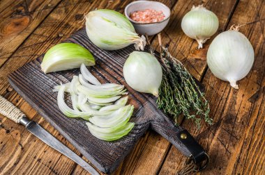 Tahta kesme tahtasında dilimlenmiş çiğ beyaz soğan. Ahşap arka plan. Üst görünüm.