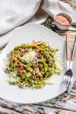 Deniz mahsullü ıspanaklı makarna, tabakta yeşil fettuccine. Beyaz arka plan. Üst görünüm.