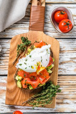 Füme somon ve haşlanmış yumurtalı tost. Beyaz ahşap arka plan. Üst görünüm.